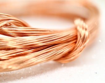 May include: Close-up of a bundle of shiny copper wire, twisted and coiled together. The wire has a warm, reddish-brown color and a smooth, metallic finish.