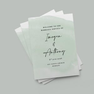 May include: A pile of wedding service booklets with a pale green watercolour design. The text reads "Welcome to the Marriage Service of Imogen & Anthony", with the date and church location below.
