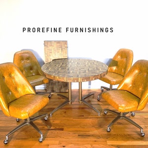 May include: A set of four swivel chairs with a round table. The chairs are upholstered in a mustard yellow fabric and have a chrome base. The table has a wood veneer top with a geometric pattern. The table and chairs are in a mid-century modern style.