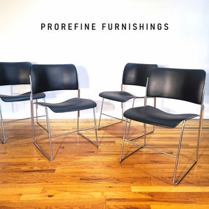 May include: Four black leather chairs with chrome frames. The chairs are arranged in a row on a wooden floor. The text "PROREFINE FURNISHINGS" is visible at the top of the image.
