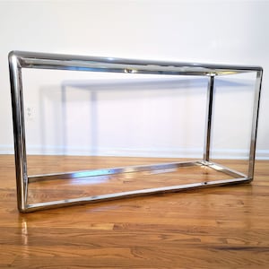 May include: A chrome console table with a rectangular top and a simple, open frame design.