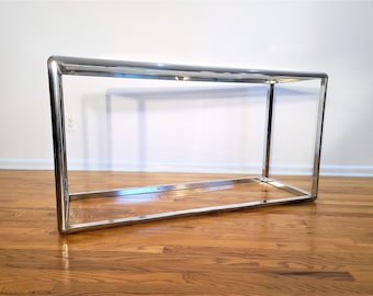 May include: A chrome console table with a rectangular top and a simple, open frame design.