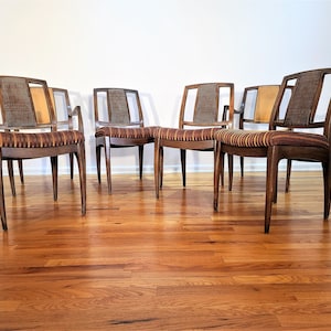May include: Set of four mid-century modern dining chairs with brown wood frames and striped fabric seats.