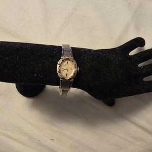 vintage Bulova, acier inoxydable, cadran texturé, étoile, fabrication suisse, remontage manuel, montre femme pour femme