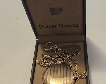 Hola compradores. Estan comprando un reloj de bolsillo vintage de cuarzo con fecha y dia chapado en oro Pulsar para hombre