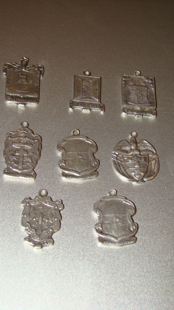 Eight Vintage heraldic 900 silver charms