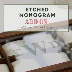 May include: A wooden watch box with a glass top. The box has multiple compartments for storing watches. The glass top is etched with the initials "CWD". The text on the box reads "Etched Monogram Add On - NOT a watch box listing - "