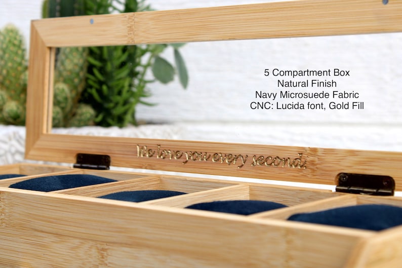 May include: A wooden watch box with a glass top and five compartments lined with navy blue fabric. The box has a natural finish and is engraved with the text "I love you every second".