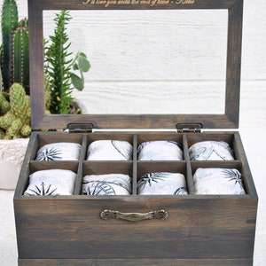 May include: A wooden drawer box with a glass top and a pull-out drawer. The box has eight compartments lined with fabric featuring a compass design. The top of the box is engraved with the text "I'll love you until the end of time - Kellie".