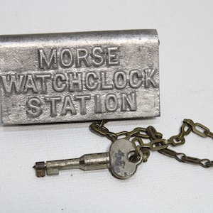 May include: A silver metal lock with a chain and key. The lock has the words "MORSE WATCHCLOCK STATION" embossed on it.