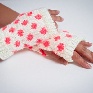 May include: A pair of white fingerless gloves with pink polka dots.