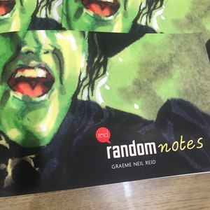 May include: A black and green book with the title "random notes" and the author's name "GRAEEME NEIL REID" printed on the cover. The cover features a close-up of a green-skinned woman's face with her mouth open in a scream.
