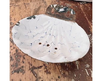 Peut inclure: Porte-savon en céramique blanche avec un effet craquelé et des veines bleu foncé. Il présente trois trous de drainage et un support métallique pour l'accrochage. Design rustique et fait à la main, environ 15 cm de long.
