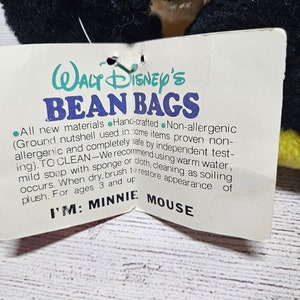 May include: A black plush toy with a tag that reads "Walt Disney's Bean Bags". The tag also says "I'M: MINNIE MOUSE". The plush toy has black fur and yellow accents.