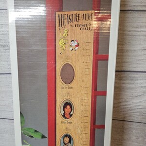 May include: Wooden height chart with the text "Measure-Me" and "Growing Chart". It features a giraffe and two children illustrations. Includes photo frames for each grade level, from fourth to sixth grade.