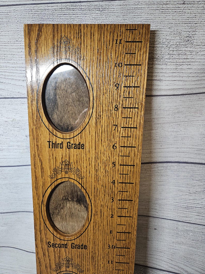 May include: Wooden growth chart with two oval photo frames and height markings. The chart has the words "Third Grade" and "Second Grade" above and below the frames. The height markings are in feet and inches.