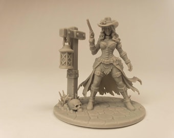 Puede incluir: Una figura en miniatura de color gris claro de una vaquera sobre una base de adoquines. La figura lleva un sombrero de ala ancha, corsé y falda harapienta, sosteniendo una pistola. A su lado hay un poste de madera con una linterna colgante.