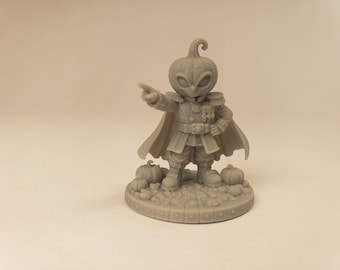 Puede incluir: Una figura miniatura de resina gris de un personaje con cabeza de calabaza, que viste un uniforme de estilo militar con charreteras, medallas y una capa. La figura se encuentra sobre una base circular decorada con pequeñas calabazas.