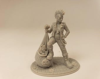 Puede incluir: Una figura miniatura de resina gris que representa a una persona con peinado mohicano, vistiendo una chaqueta con tachuelas y pantalones. La figura apoya un pie sobre un saco grande lleno de dulces, con un diseño de cara de calabaza tallada.