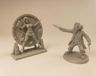 Puede incluir: Un conjunto de miniaturas de resina gris que muestra una figura atada a una rueda de lanzamiento circular de estilo madera y una segunda figura vestida de payaso con cuchillos en ambas manos, sobre una base circular, esculpidas con gran detalle.