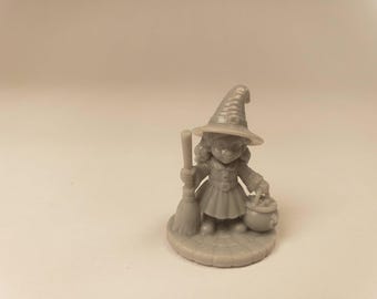 Puede incluir: Una pequeña figura monocromática gris de una bruja sobre una base circular. El personaje lleva un sombrero puntiagudo y un vestido con cinturón, sosteniendo una escoba en la mano derecha y un pequeño caldero redondo en la mano izquierda.