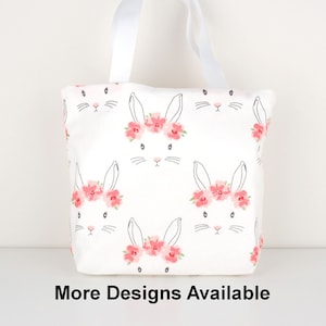 May include: White tote bag with a floral bunny pattern. The bag has two white handles.