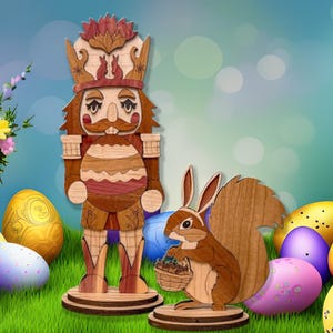 May include: Wooden Easter nutcracker figurine with a brown, red, and white painted design holding a large egg. A smaller wooden squirrel figurine with a brown painted design is holding a basket of eggs. Both figurines are standing on a green grassy surface with colorful Easter eggs.