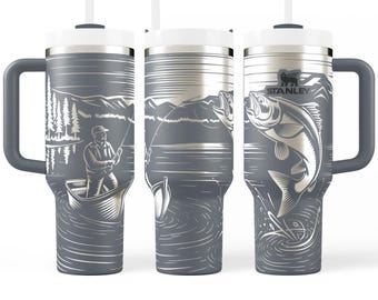Könnte beinhalten: Grauer Stanley-Becher mit weißem Deckel und Griff, der eine Angelszene zeigt. Das Design zeigt einen Fischer in einem Boot, Bäume, Berge und springende Fische. Das Stanley-Logo ist sichtbar.
