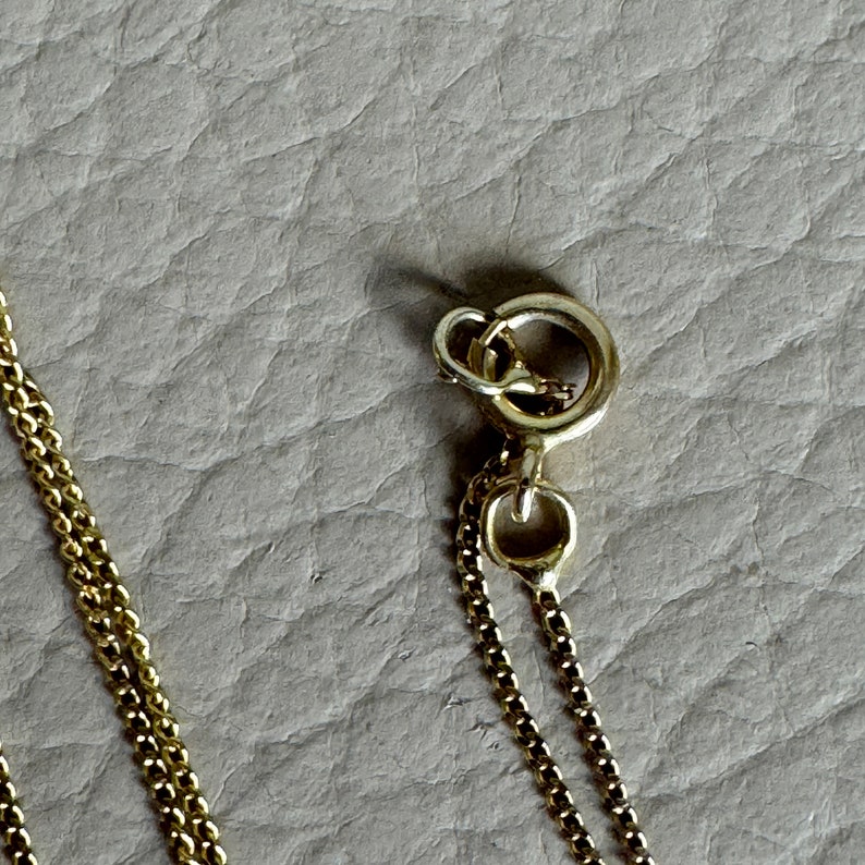 May include: A gold chain necklace with a lobster clasp closure.