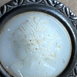 Peut inclure: Un bouton en verre blanc avec un motif floral en relief. Le bouton est mont&eacute; dans un cadre en m&eacute;tal argent&eacute; avec un bord d&eacute;coratif.