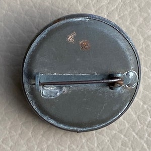 Peut inclure: L'arri&egrave;re d'une &eacute;pingle ronde en m&eacute;tal vert avec un fermoir en m&eacute;tal.