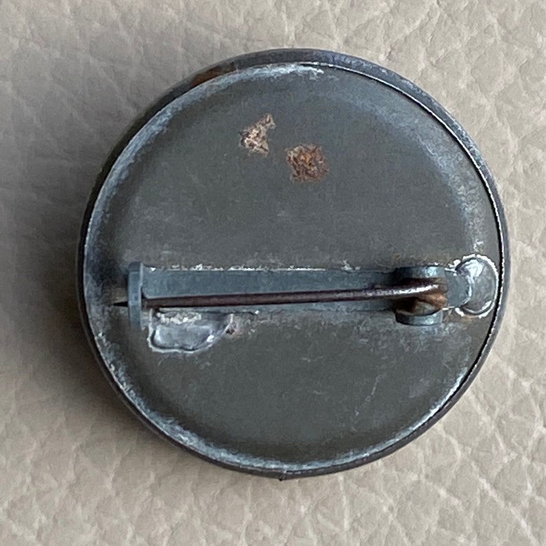 Peut inclure: L'arri&egrave;re d'une &eacute;pingle ronde en m&eacute;tal vert avec un fermoir en m&eacute;tal.