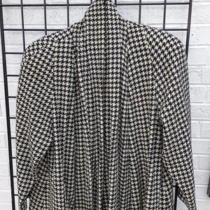 May include: A black and white houndstooth patterned cardigan with a long, open front.