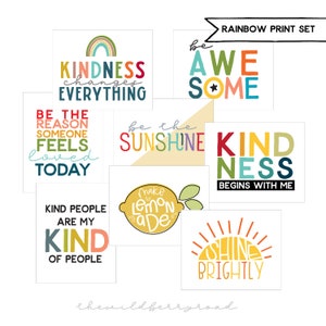 May include: A collection of square art prints with positive messages in various colors. Phrases include "Kindness Changes Everything," "Be Awesome," and "Be the Sunshine." The prints feature a rainbow, lemon, and sun graphic. The set is labeled "Rainbow Print Set."