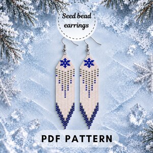 May include: A pair of long, dangling seed bead earrings featuring a white background with a blue snowflake motif at the top and a blue geometric fringe pattern at the bottom. The text "Seed bead earrings" and "PDF PATTERN" are visible.