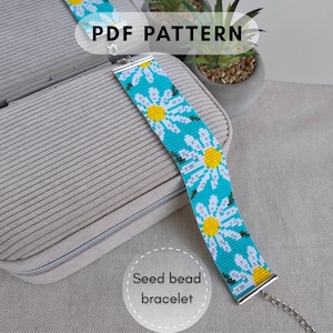 May include: A seed bead bracelet featuring a repeating pattern of white daisies with yellow centers on a bright turquoise background. The bracelet has silver-toned metal end caps and a chain extension. The text PDF PATTERN is visible.
