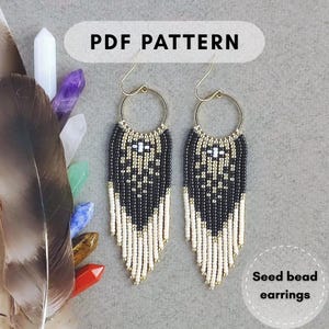 Puede incluir: Pendientes de cuentas de semillas en blanco y negro con detalles dorados y flecos. Los pendientes se muestran con una pluma y cristales. El texto "PDF PATTERN" está en la parte superior de la imagen. El texto "Seed bead earrings" está en la parte inferior.
