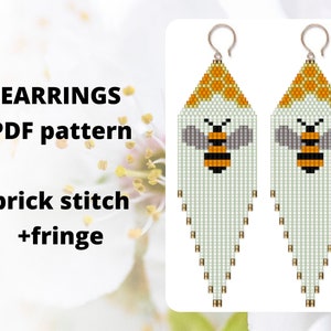 May include: A pair of white beaded earrings with a bee design and a fringe. The earrings are made with brick stitch and have a yellow honeycomb pattern at the top. The text "EARRINGS PDF pattern brick stitch +fringe" is visible in the image.