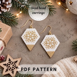 Pode incluir: Um par de brincos geométricos de missangas com um padrão de floco de neve branco e dourado. Os brincos têm uma extremidade inferior pontiaguda e ganchos de metal dourado. O texto "Seed bead earrings" e "PDF PATTERN" é visível.