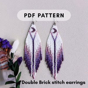 May include: PDF pattern for Double Brick stitch earrings. The earrings are white, purple, and pink with a crescent moon design. The earrings have a fringe design and are displayed on a light gray surface.