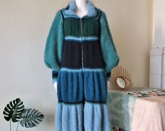 May include: A long, blue and green striped knitted coat with a zipper closure. The coat has a fluffy texture and a wide collar.
