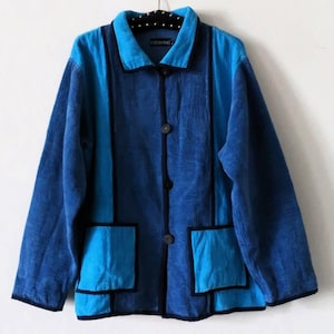 May include: A blue and turquoise jacket with black trim and buttons. The jacket has two patch pockets and a label that reads "DENIM HANG".