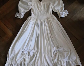 Vintage white cotton maxi dress bohemian bridal gown with dramatic puff sleeves bows and ruffles 1980s 80s