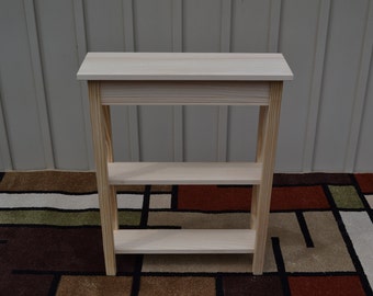 May include: A natural wood console table with two shelves. The table is unfinished and has a simple design.