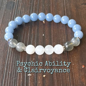 May include: A blue and white beaded bracelet with silver accents. The bracelet has the text "Psychic Ability & Clairvoyance" printed below it.