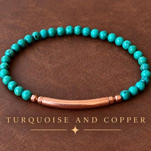 Puede incluir: Una pulsera de cuentas con pequeñas piedras redondas de color turquesa dispuestas en un patrón circular. El diseño incluye una cuenta de metal cilíndrica, lisa y de tono cobre en el centro, flanqueada por dos cuentas espaciadoras de tono cobre.