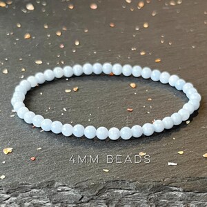 Puede incluir: Una pulsera de cuentas azul claro. La pulsera est&aacute; hecha de peque&ntilde;as cuentas redondas, de aproximadamente 4 mm de di&aacute;metro. El texto "4MM BEADS" es visible en la imagen.