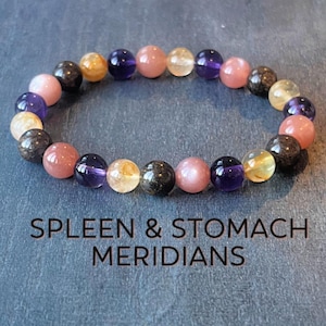 Könnte beinhalten: Ein Armband aus Amethyst-, Sunstone- und Rosenquarzperlen. Das Armband ist so konzipiert, dass es die Milz- und Magenmeridiane unterstützt.
