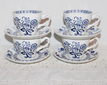 May include: Set of four blue and white floral teacups and saucers. The cups and saucers have a delicate floral pattern in blue on a white background.