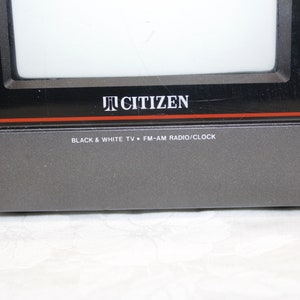 May include: A black and gray Citizen brand portable television with a black and white screen. The text "BLACK & WHITE TV * FM-AM RADIO/CLOCK" is printed on the front of the television.